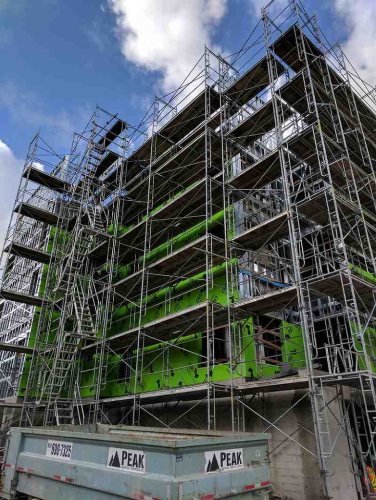 An ongoing building construction featuring scaffolding stair and stair towers.