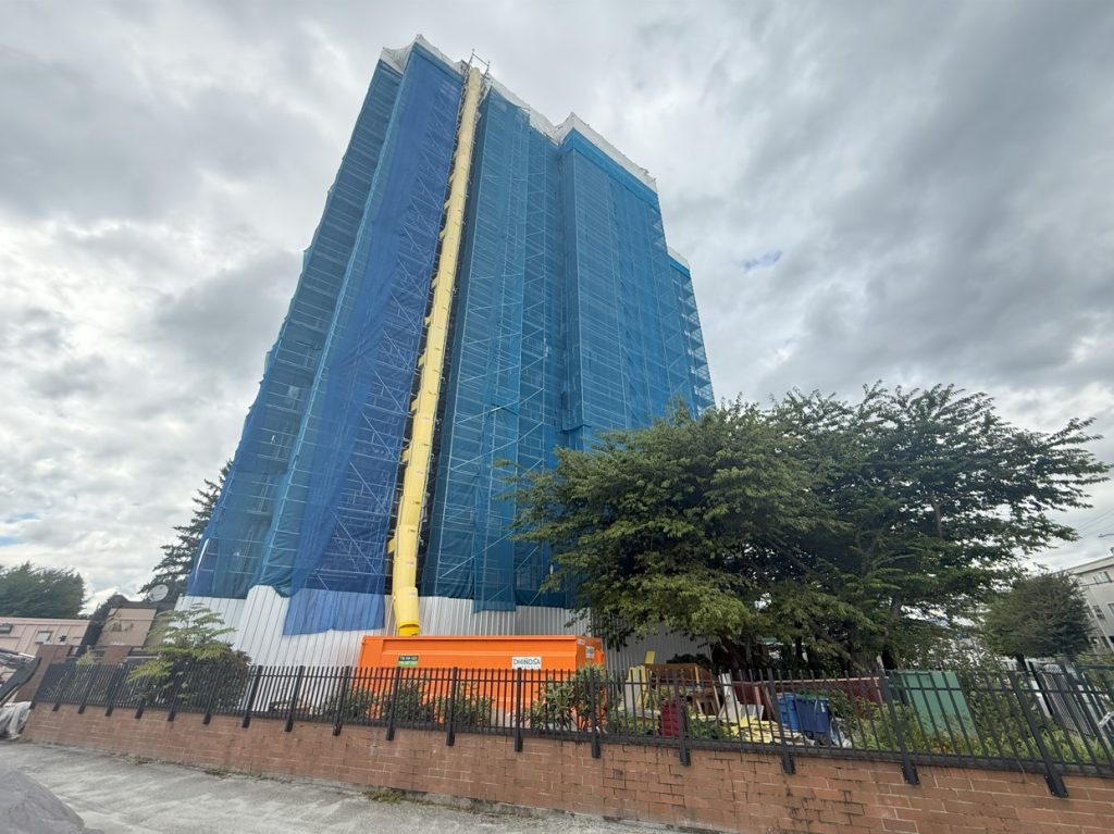 Residential high-rise in Maple Ridge, BC scaffolded with North Scaffold Products’ Ringlock system, including stair towers, debris mesh, and garbage chutes to provide enclosed, safe exterior access for renovation work.